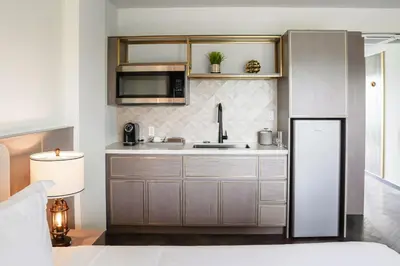 a kitchen with a sink and a refrigerator at Barley House Hotel, Trademark Collection by Wyndham in Fort Lauderdale