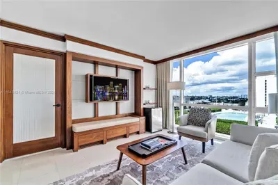 a living room with a tv and a couch and a table at Carillon Miami Beach Private Luxury Suites in Miami Beach