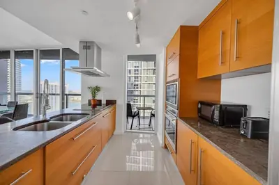 a kitchen with a sink and a microwave at Sun, Style and Skyline Modern Icon Brickell 2BR in Miami