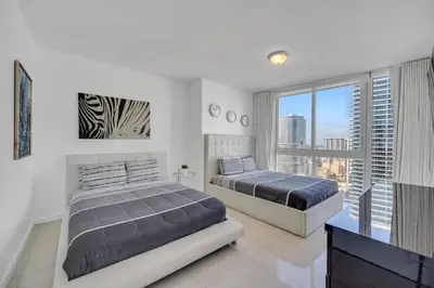 two beds in a bedroom with a view of a city at Sun, Style and Skyline Modern Icon Brickell 2BR in Miami