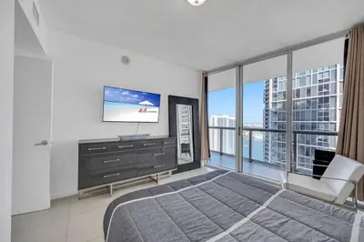 a bedroom with a large bed and a television at Sun, Style and Skyline Modern Icon Brickell 2BR in Miami