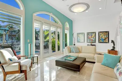 a living room with a couch and chairs and windows at Massive waterfront home with pool in North Miami Beach