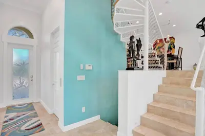 a staircase in a home with a blue wall at Massive waterfront home with pool in North Miami Beach