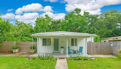 a small white house with a wooden fence at Avocado House A Coconut Grove Bungalow in Miami