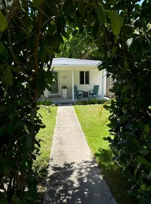 a garden path leading to a house with a patio at Avocado House A Coconut Grove Bungalow in Miami
