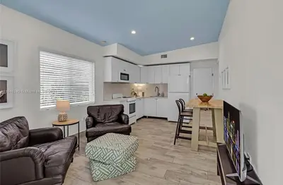 a living room with a couch and chairs and a kitchen at Avocado House A Coconut Grove Bungalow in Miami