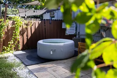 a bath tub sitting in a yard next to a fence at 10 min to Las Olas and Beach WD 2 Bed in Fort Lauderdale