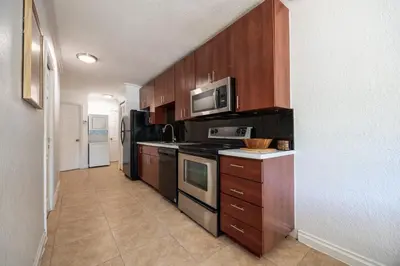 a kitchen with wooden cabinets and a stove top oven at 10 min to Las Olas and Beach WD 2 Bed in Fort Lauderdale