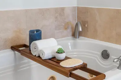 a bathroom with a bath tub with towels and a shelf at Ocean View Private Residence at Fontainebleau -3505 in Miami Beach