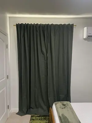a bedroom with a green curtain on a bed at Tropical Oasis in Pembroke Pines