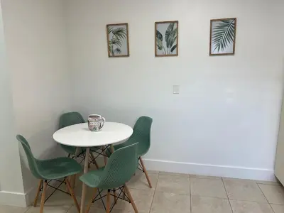 a white table with green chairs in a room at Tropical Oasis in Pembroke Pines