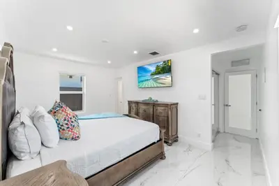 a bedroom with a bed and a tv on the wall at Family Splash Escape in Fort Lauderdale