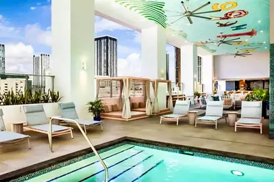 a hotel patio with a pool and chairs and a clock at The Art Studio Downtown in Miami