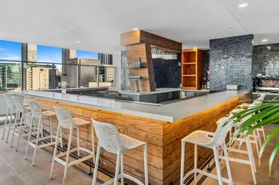 a kitchen with a bar with white bar stools at The Art Studio Downtown in Miami