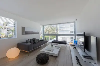 a living room with a couch and a tv at Beach Haus Key Biscayne Contemporary Apartments in Miami