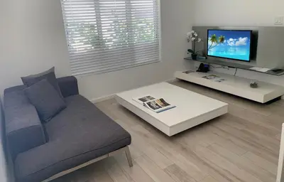 a living room with a couch and a tv at Beach Haus Key Biscayne Contemporary Apartments in Miami