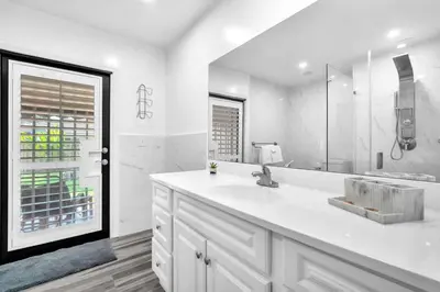 a white bathroom with a sink and a mirror at Lime Haus lime - Your Family Stay in Miami Awaits in Tamiami