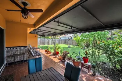 an outdoor patio with a ceiling fan and plants at Lime Haus lime - Your Family Stay in Miami Awaits in Tamiami