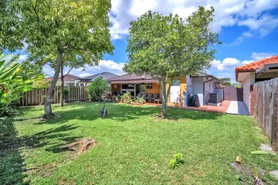 a yard with two trees and a fence at Lime Haus lime - Your Family Stay in Miami Awaits in Tamiami