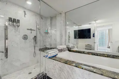 a bathroom with a tub and a glass shower at Tony Ultimate Experience Miami in Miami