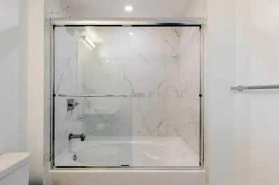 a shower with a glass door and a tub at Blueground Riverside pool AC nr parks MIA-144 in Miami