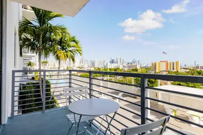 a balcony with a table and chairs and a view of the city at Blueground Riverside pool AC nr parks MIA-144 in Miami