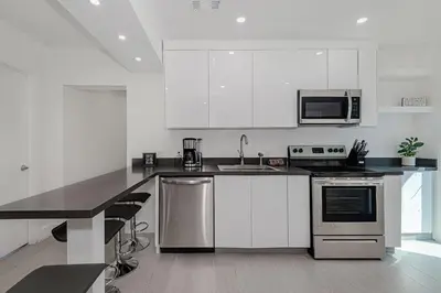 a kitchen with white cabinets and stainless steel appliances at Stylish Apartment at Brickell ,Free Parking in Miami