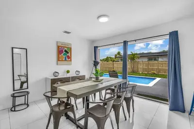 a dining room with a table and chairs and a pool at Private Pool Home & Arcade game & Mini Basketball in Hollywood