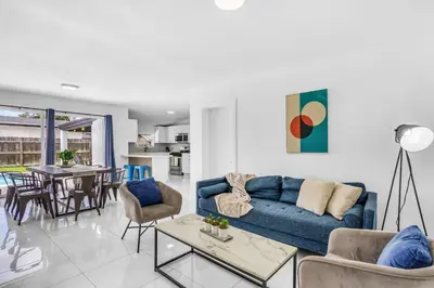 a living room with a blue couch and a table at Private Pool Home & Arcade game & Mini Basketball in Hollywood