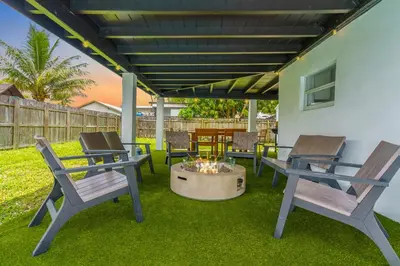 a patio with three chairs and a fire pit at Private Pool Home & Arcade game & Mini Basketball in Hollywood