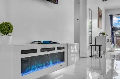a white living room with a fireplace and a tv at Private Pool Home & Arcade game & Mini Basketball in Hollywood
