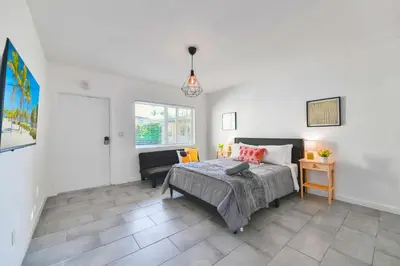 a bedroom with a bed and a chair in it at Charming Studio in a Beautiful Neighborhood Setting in Miami