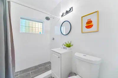 a white bathroom with a toilet and a shower at Charming Studio in a Beautiful Neighborhood Setting in Miami