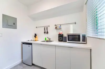 a kitchen with a counter with a microwave and a sink at Charming Studio in a Beautiful Neighborhood Setting in Miami