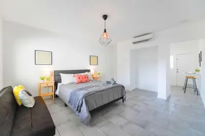 a bedroom with a bed and a couch at Charming Studio in a Beautiful Neighborhood Setting in Miami