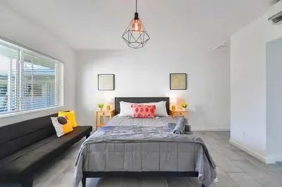 a bedroom with a large bed and a couch at Charming Studio in a Beautiful Neighborhood Setting in Miami