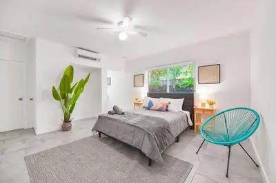 a bedroom with a bed and a blue chair at Charming Miami Studio in Prime Location in Miami