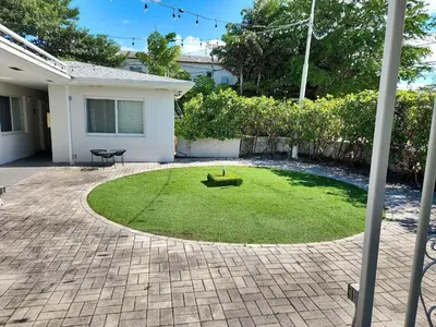 a yard with a circle of grass in front of a house at Charming Miami Studio in Prime Location in Miami