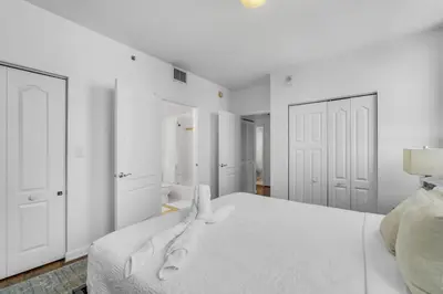 a white bedroom with a bed and white cabinets at City-View Retreat in Brickell 2BR and Free Parking in Miami