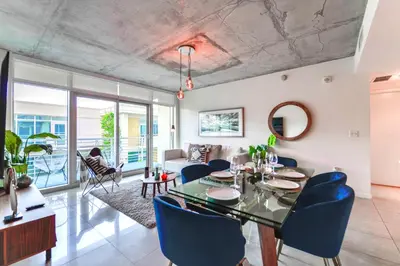 a dining room with a table and blue chairs at Stylish Midtown Miami Condo - Pool & Prime Location in Miami