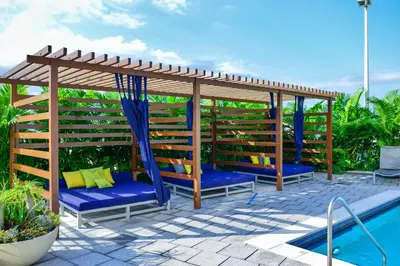 a wooden pergola next to a swimming pool at Stylish Midtown Miami Condo - Pool & Prime Location in Miami