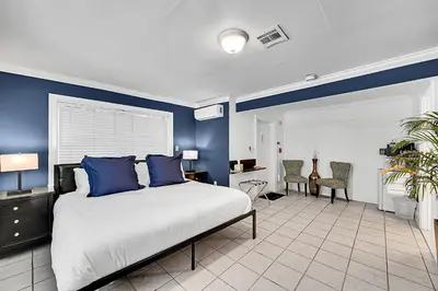 a bedroom with blue walls and a bed with blue pillows at Inn On The Drive in Fort Lauderdale