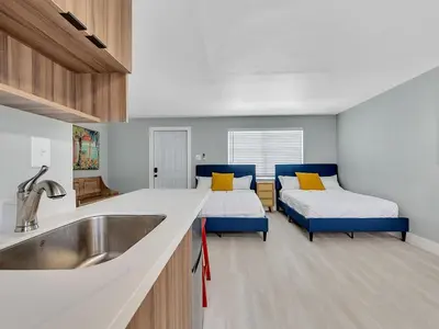 a kitchen with two beds and a sink in a room at Beachside 1BR in Hollywood | Parking + WiFi in Dania Beach