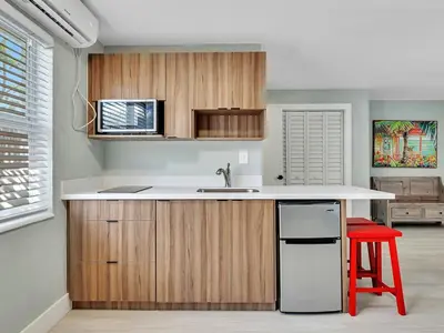 a kitchen with a sink and a red stool at Beachside 1BR in Hollywood | Parking + WiFi in Dania Beach