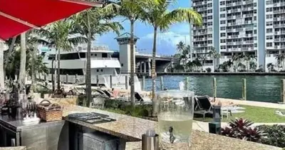 a drink sitting on a table in front of a pool at Modern Condo by the Beach, Water Taxi Stop, Prime Location! in Fort Lauderdale