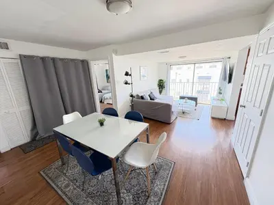 a dining room and living room with a table and chairs at South Beach and Collins, Parking included in Miami Beach
