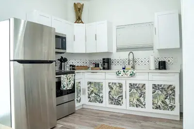 a kitchen with white cabinets and a stainless steel refrigerator at Havana Oh Na Na Unit C in Miami