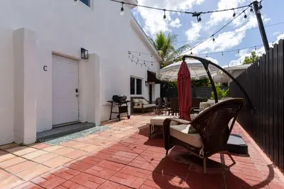 a patio with chairs and an umbrella in a house at Havana Oh Na Na Unit C in Miami