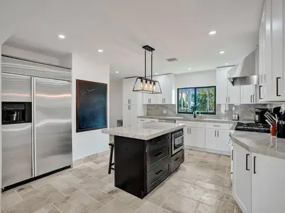 a kitchen with white cabinets and stainless steel appliances at Villa Riverland in Fort Lauderdale