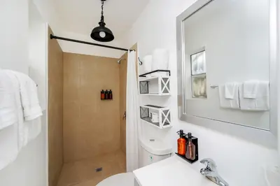 a bathroom with a shower and a toilet and a sink at Alton Rd By At Mine Hospitality in Miami Beach